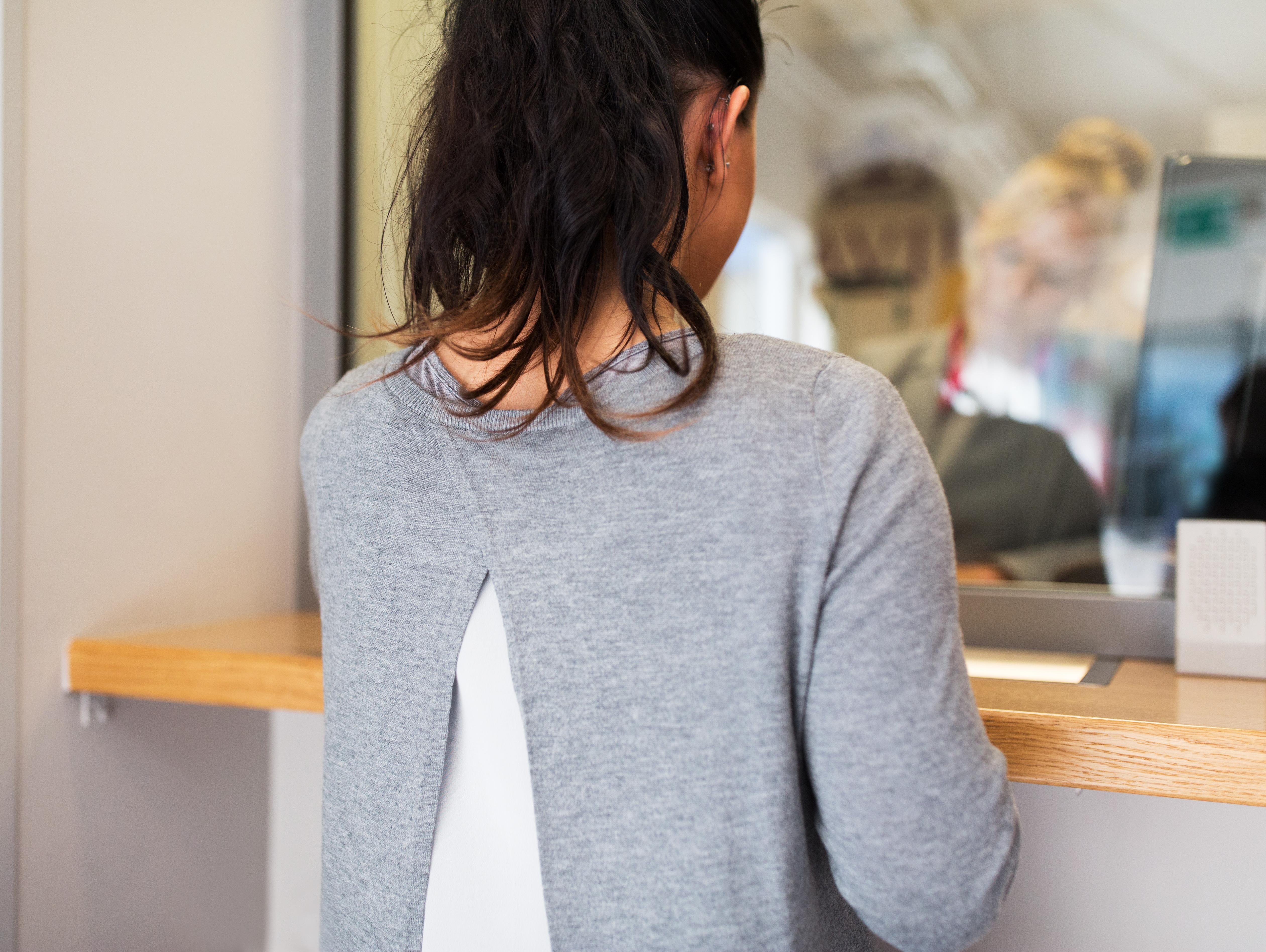 people and finance concept - customer at bank office window or currency exchanger