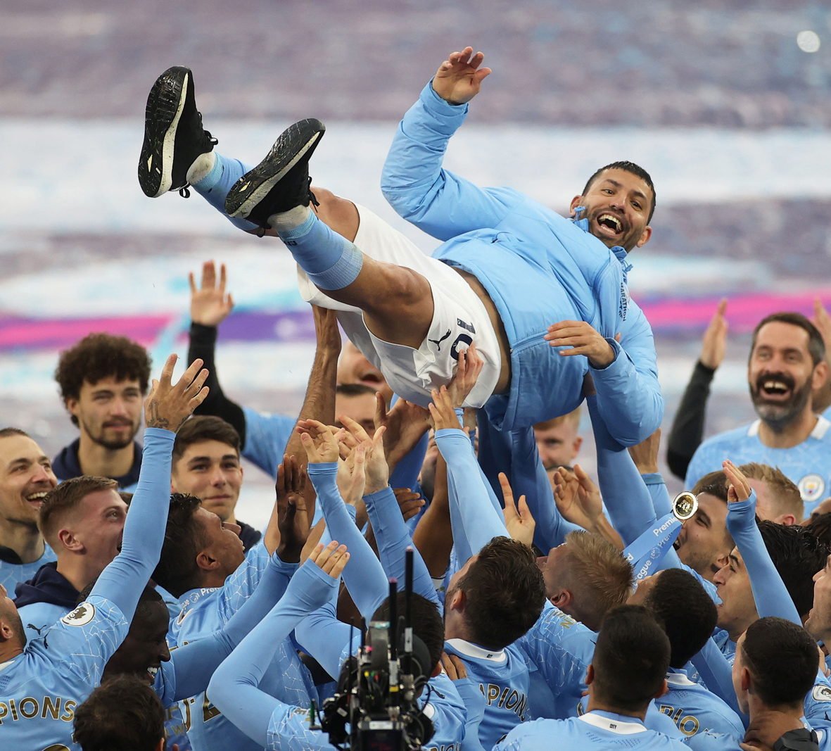 Soccer Football - Premier League - Manchester City v Everton - Etihad Stadium, Manchester, Britain - May 23, 2021 Manchester City's Sergio Aguero is thrown in the air by teammates as they celebrate winning the Premier League after his last match at the Etihad Stadium as a Manchester City player Pool via REUTERS/Carl Recine EDITORIAL USE ONLY. No use with unauthorized audio, video, data, fixture lists, club/league logos or 'live' services. Online in-match use limited to 75 images, no video emulation. No use in betting, games or single club /league/player publications.  Please contact your account representative for further details.     TPX IMAGES OF THE DAY-FDCL